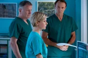 Dr. Roland Heilmann (Thomas Rühmann, li.) und Dr. Martin Stein (Bernhard Bettermann, re.) stehen ihrer Freundin und Kollegin Dr. Kathrin Globisch (Andrea Kathrin Loewig, mi.) in diesen schweren Stunden bei.