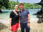 Die Reiseleiter Maika und Bernd am Strand Sulamadaha Beach auf der Insel Ternate, Indonesien, wo sie einen Bootsausflug unternehmen wollen. Der Strand ist für sein kristallklares Wasser bekannt, weshalb er auch als Glasstrand bezeichnet wird.
