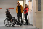 Die Bergretter Katharina (Luise Bähr, r.) und Markus (Sebastian Ströbel, M.) erkundigen sich bei Anton Zeller (Max Herbrechter, l.) nach seiner verunglückten Tochter und dem Baby.