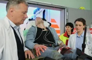 Nachdem nach einem Banküberfall eine angeschossene Polizistin eingeliefert wurde, hat die Polizei nun den Täter (Jorres Risse, liegend) gefasst. Auch er ist verletzt. Dr. Roland Heilmann (Thomas Rühmann, li.) und Dr. Maria Weber (Annett Renneberg, re.) vermuten, dass der Schuss die Arterie verletzt hat. Durch die genaue Projektilbeschreibung der Notärztin (Sarah Arntz, 2.v.re.) können die beiden Ärzte das Ausmaß halbwegs einschätzen.
