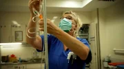 Eine Krankenschwester bereitet eine Infusion für einen Patienten vor.