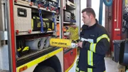 A firefighter prepares equipment.
