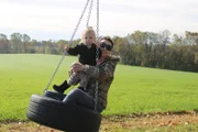 Rebecca and her daughter on a tire swing.