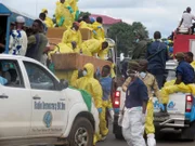 The coffins of victims of a mudslide are carried to the cemetery on trucks draped with the Sierra Leone flag in Freetown, Sierra Leone.