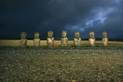Steinerne Überlebende einer untergegangenen Kultur blicken auf eine Vulkanlandschaft, Osterinsel, Polynesien, Pazifische Inseln.
