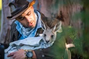 Coyote Peterson holding baby kangaroo.