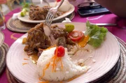 Einem leckeren Chicken Yassa kann kaum jemand widerstehen. Für das senegalesische Gericht braucht man Hähnchen, Zitronen und Zwiebeln.