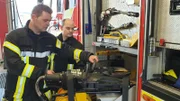 Die Feuerwehrleute bereiten in aller Ruhe die notwendigen Werkzeuge vor, um das Feuer zu löschen.