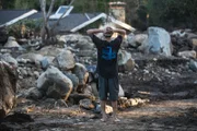 Travis Zehntner looks over wreckage of home on Glen Oaks Drive where family friend Rebecca Riskin was killed in the mudslide along San Ysidro Creek.
