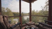 Interior, enclosed patio, at Enchanted Ridge house, chairs facing lake view, near Eagle River, Alaska, as seen on Great American Country's Living Alaska