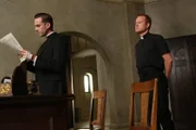 Bruder James (Kasey Mahaffy, r.) teilt Monsignor Timothy Howard (Joseph Fiennes, l.) mit, dass Briarcliff von Journalisten und Fotografen belagert wird, die auf eine Stellungnahme warten ...