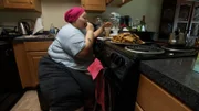 Brittani eating food in the kitchen.