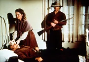 Nach einem Überfall auf die Blindenschule beobachtet Bandenchef Jake (James McIntire, r.), wie Mary Kendall (Melissa Sue Anderson, M.) sich um seinen verletzten Kumpan Abel (Larry Golden, liegend) kümmert.