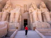Hannah Emde am Portal von Abu Simbel. Vier gigantische Figuren von König Ramses II. zieren den Eingang des Tempels. Die Geschichte des Tempels zeugt von den dramatischen Umwälzungen in Ägypten.