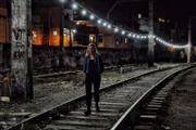 Mariana van Zeller walking on railway tracks.