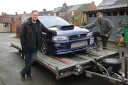 West Midlands, United Kingdom - Tim and Fuzz pose with the Subaru on the trailer ready to be taken back to the workshop.