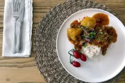 In Südafrika bereitet Kelly Lammragout mit Tomaten, Paprika und verschiedenen Gewürzen zu.