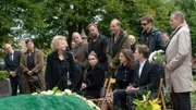 Familie und Angehörige trauern am Sarg.