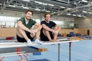 Tobi (rechts) checkt mit Turn-Trainer Erik, was er an den Geräten so drauf hat. Zum Beispiel am Barren, auf dem die beiden gerade sitzen.