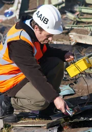 Binbrook, Ontario: AAIB Support Manager Sid Hawkins (gespielt von Richard Alan Campbell) inspiziert die Trümmer auf Uranballast. Die Boeing 747 verwendet abgereichertes Uran als Gewichte im Heckbereich. Er muss feststellen, ob die Gewichte genügend Hitze ausgesetzt waren, um sie radioaktiv zu machen.