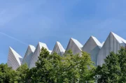 Wie eine Reihenhaus-Siedlung wirkt die Straßenfassade aus zahlreichen Spitzgiebeln.