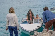 Miranda (Elen Rhys, l.) und Max (Julian Looman, r.) sitzen auf der Insel fest. Doch plötzlich taucht ein anderes Boot auf – zwei Unbekannte (Michael Jibson, 2.v.l. und Caroline Sheen, 2.v.r.) steuern direkt auf sie zu.