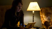 Heather looking at a tablet under the light.