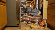 Nikki putting up groceries in the kitchen.