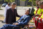 Dr. Harald Reimers (Olaf Burmeister, liegend) wird vom RTW in die Sachsenklinik gebracht. Begleitet wird der Tross von Dr. Rolf Kaminski (Udo Schenk, li.).
