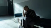 Silke Weinzierl (Nina Proll) sitzt in der Ausnüchterungszelle und hält sich den Kopf.