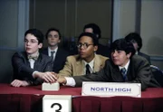 vorne: Kevin (Victor Z. Isaac, li.), Stevie (Craig Lamar Traylor, mi.) und Lloyd (Evan Matthew Cohen, re.) geben beim akademischen Achtkampf ihr Bestes. Malcolm (Frankie Muniz, hi.li.), Mr. Herkabe (Chris Eigeman, hi.mi.) und Dabney (Kyle Sullivan, hi.re.) sehen gespannt zu.