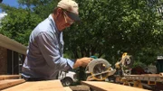 Host Chip Gaines cuts wood for the new vaulted ceiling in the McKenzie's living room on HGTV's Fixer Upper.