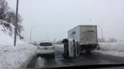 Ein PKW liegt auf der Seite zwischen einem anderen PKW und einem LKW