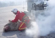 Werksleiter Gruber (Hermann Giefer) liegt nach dem Rückstoss durch das Gas verkrampft auf dem Dach. Sanitäter Ralf Staller (Wolfgang Krewe) leistet erste Hilfe.