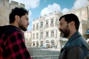 Komplize Ashraf (Amir Khoury, li.) soll Momi (Yehuda Levi, re.) dabei helfen, den Kauf des besonders gut gelegenen Hotels St. George (im Hintergrund) einzufädeln.