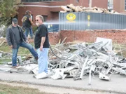 Brian Gurry and Lee Danley discuss the salvage while Jim Basett is hosing down all the dust and debris.
