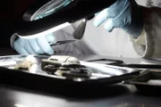 Ein Gerichtsmediziner untersucht die Waffe, mit der die Morde begangen wurden.