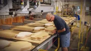 Gibson worker cutting guitar shape from wood.