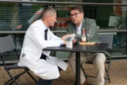 Dr. Bruno Herzog (Albrecht Ganskopf, re.) erzählt seinem alten Freund Dr. Rolf Kaminski (Udo Schenk, li.), dass die letzten Jahre ganz anders verlaufen sind, als er Rolf weismachen wollte.