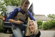 Lisa (Susan Sideropoulos, l.), die die wahre Vergangenheit Toms kennt, ist im Umgang mit ihm total verunsichert, was dessen Deckung stark gefährdet. Als sie schließlich in Sorge um Toms Kinder einen Polizeigroßeinsatz veranlasst und Zeugenschützerin Vera Behringer (Hedi Kriegeskotte, r.) öffentlich angreift, ruft sie Kripochef Pohl auf den Plan ...