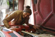 Fuzz leaning over engine of Toyota Celica in the pick-up home