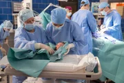 Julia Berger (Mirka Pigulla, 2.v.l.) animiert das Baby zum Atmen (mit Komparsin, l.). Im HG Dr. Niklas Ahrend (Roy Peter Link, 2.v.r.) und Elias Bähr (Stefan Ruppe, r.)