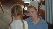 Rebecca in amish clothes talking to a girl.