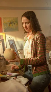 Die Frau schaut auf das Teil des Spielzeugs, das sie in der Hand hält.