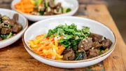 Sommerlicher Rinderschmortopf mit orientalischer Gewürzpaste, Möhren-Mango-Salat, frischen Kräutern und Reis.