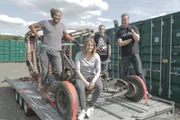 Tim Shaw, Fuzz Townshend, Victoria Farr, Tom Farr, children and nominators of the nominee Craig Farr, sitting on trailer at storage park.