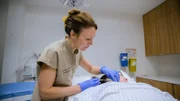 Wide Shot of Dr Emma injecting anaesthetic into Kelly A's cheek