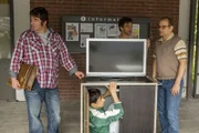 Stefan Vollmer (Hendrik Duryn) will Mehmet (Zelhun Demirov, unten) vor der Abschiebung bewahren und bittet Karl (Rainer Piwek, l.) und Rüdiger (Mathias Klimsa, r.), den Videowagen samt verstecktem Mehmet mitzunehmen.