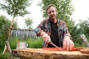 Johnny Rolfe schneidet fangfrischen Lachs und bereitet ihn zum Räuchern vor. (National Geographic/Mike Fennell)
