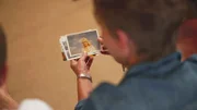 Sam, Caroles Tochter, schaut sich alte Fotos an.